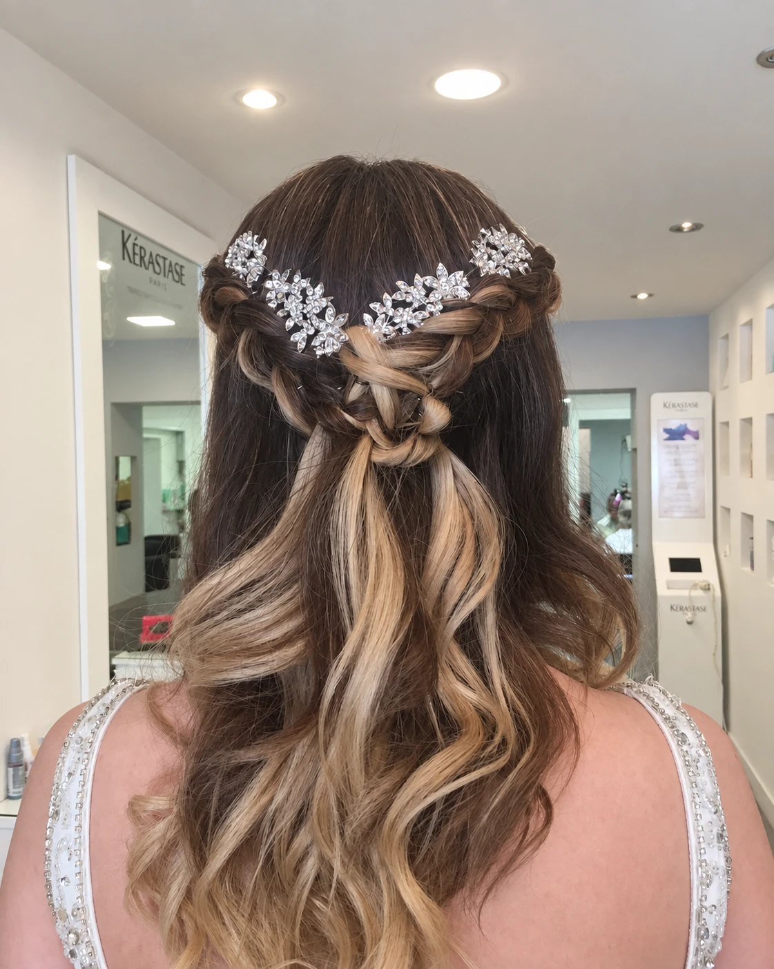 Peinado recogido con ondas sueltas y accesorios de brillo, visto desde atrás.
