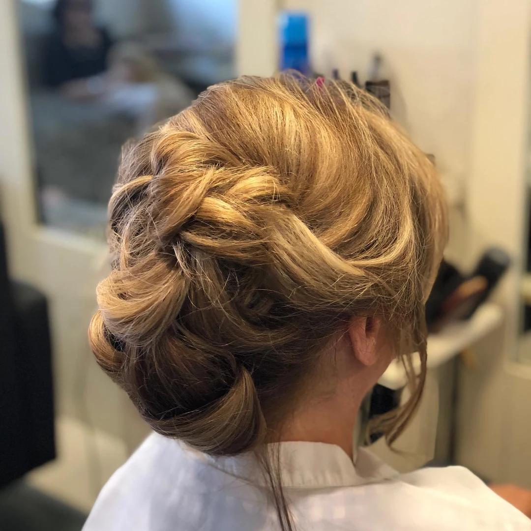 Peinado recogido con trenzas y ondas suaves visto desde atrás.